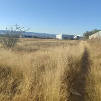 Terreno amplio con vegetación seca y servicios cercanos
